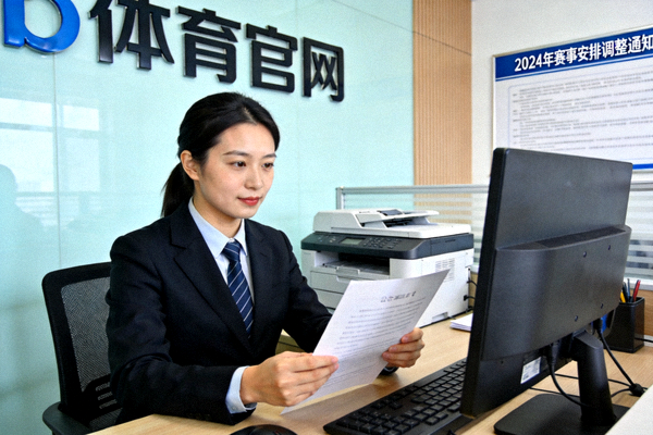 b体育官网官方资讯发布场景，工作人员核对公告内容的画面